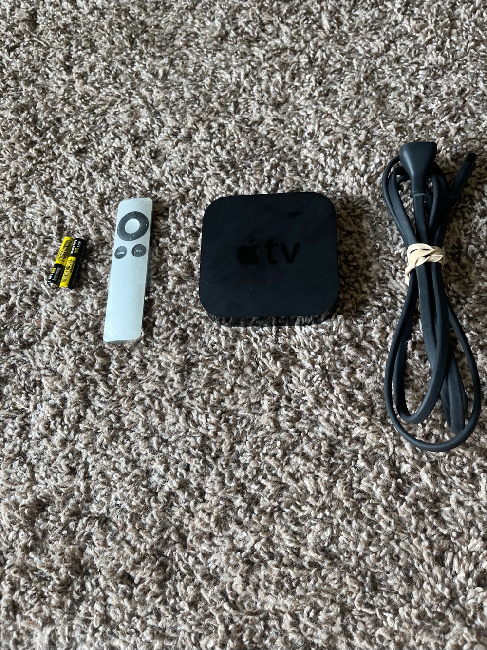 Apple TV with Silver Remote and Black Power Cable